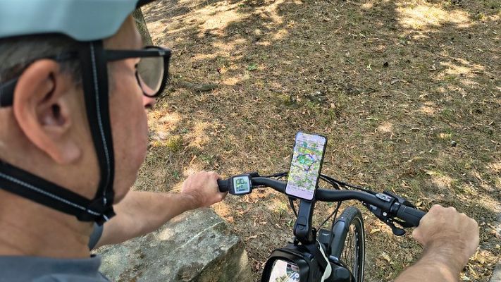 Cyclist using a navigation app on an e‑bike during a ride