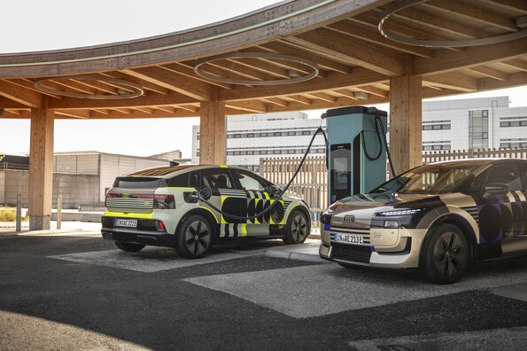 Audi A2 e-tron with design foil, outdoor still shot of two Audi A2 e-tron at a charging station